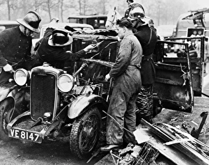 Firemen and mechanic with burnt-out car, London Firemen and mechanic with burnt-out car, London