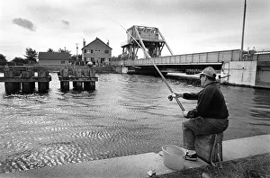 A fisherman sits on the towpath of the Caen Canal A fisherman sits on the towpath of the Caen Canal