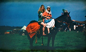 Two girls at a fair in medieval costume on horseback Two girls at a fair in medieval costume on horseback