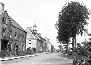 Prints of Gracehill, Ballymena - a street scene of this Moravian settlement with a car in the distance. (Location: Northern Ireland; County Antrim; Gracehill). Date: circa early 1900s County Antrim Prints: Early 20th Century Gracehill Street Scene Print