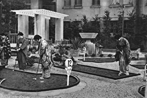 A group of Japanese women play miniature golf A group of Japanese women play miniature golf