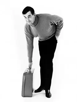 Late 1960s Print: Man Picking Up Suitcase