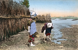 Japan, Two children digging for shellfish, low tide riverbed Japan, Two children digging for shellfish, low tide riverbed