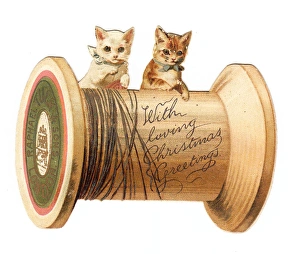 Two kittens with cotton reel on a cutout Christmas card Two kittens with cotton reel on a cutout Christmas card