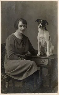 A lady and her dog pose for a studio portrait A lady and her dog pose for a studio portrait