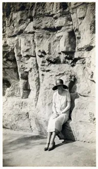Lady sitting on a natural seat beneath a rock cliff Lady sitting on a natural seat beneath a rock cliff