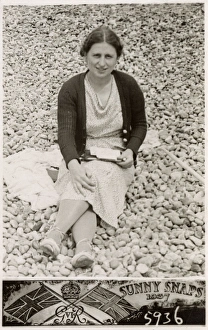 Lady on a south coast beach writing postcards to family Lady on a south coast beach writing postcards to family