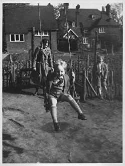 A little boy beaming widely as he gets a push on a garden swing A little boy beaming widely as he gets a push on a garden swing