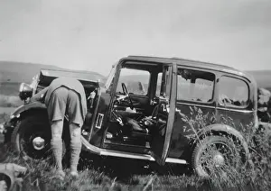 Rural Transport History Prints: Man checking car engine in a field