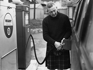 Man in a kilt, filling a van up with petrol Man in a kilt, filling a van up with petrol