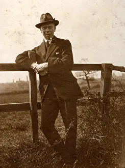 Man leaning on a fence in the countryside Man leaning on a fence in the countryside