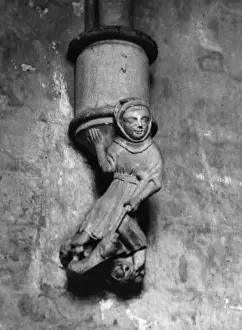 Prints of A medieval corbal of a peasant thrusting his staff into a dragons mouth, in the Chapter House of Wells Cathedral, Somerset, England. Date: 14th century Well Prints: Medieval Corbel Print: Wells Cathedral, 14th Century
