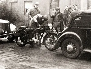 Men standing around an Ariel motorcycle Men standing around an Ariel motorcycle