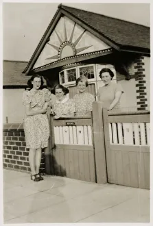 Mother and daughters by the gate of a lovely bungalow Mother and daughters by the gate of a lovely bungalow