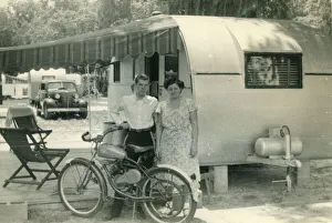 A mother and her son at a campsite or caravan park, pose for a photograph beside their A mother and her son at a campsite or caravan park, pose for a photograph beside their