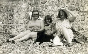 English Coastal Scene Prints: Sitting against a stone wall on a pebbly beach