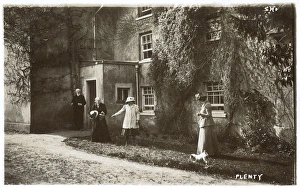 People and dog outside a large house People and dog outside a large house