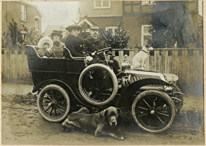 People in an early car with two dogs People in an early car with two dogs