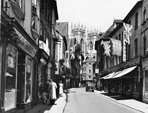 Prints of A view of Petergate, York, during festival time, with the towers of the Minster in the background York Prints: Petergate Print, York Festival Scene