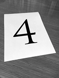 Piece of paper on a desk with a large number 4 Piece of paper on a desk with a large number 4