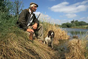 Poacher with gun and dog, Cambridgeshire fens Poacher with gun and dog, Cambridgeshire fens
