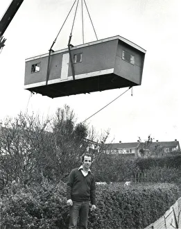 Prefabricated unit delivered to a garden by crane Prefabricated unit delivered to a garden by crane
