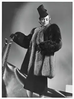 Prints of A half-length coat in two colours of fur including red fox by Marcel Rochas. The model wears a brimless hat with a tall crown Red Fox Prints: Red Fox Coat Print: A Two-Toned Fur Design