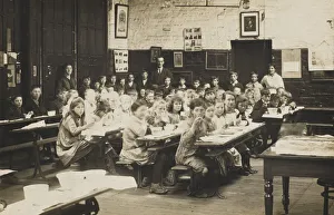 Schoolchildren ear their midday meal at their desks. Date: early 20th century Schoolchildren ear their midday meal at their desks. Date: early 20th century