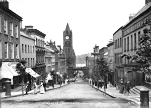 Prints of Shipquay Street, Londonderry - A street scene with shop fronts and people and horse vehicles. This view is looking down to the clock tower County Londonderry Prints: Early 20th Century Print of Shipquay Street, Londonderry
