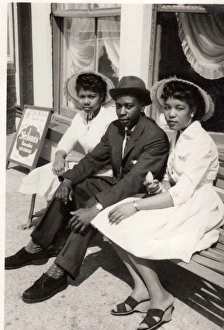 Three smartly dressed British Caribbean people sitting on be Three smartly dressed British Caribbean people sitting on be