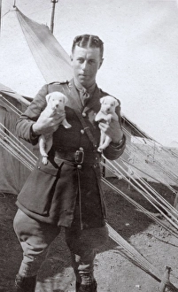Soldier at training camp holding two puppies, WW1 Soldier at training camp holding two puppies, WW1