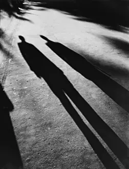 Spooky Shadows Print: Two figures cast evening shadows over a pathway