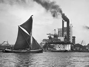 Prints of A coastal barge sailing by the famous Tate and Lyle sugar refinery works, Plaistow Wharf, off Silvertown, North Woolwich, east London Industrial Prints: Tate & Lyle Refinery Print, East London