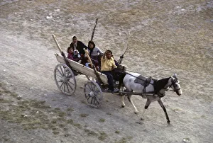 A Turkish family dash along a dusty track in a wooden cart A Turkish family dash along a dusty track in a wooden cart