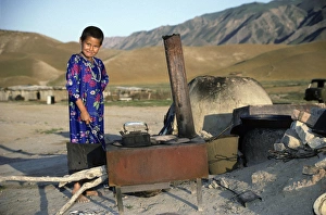 Turkmen girl - in traditional dress - boils water Turkmen girl - in traditional dress - boils water