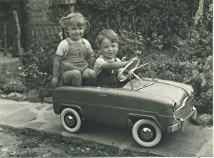 A twin brother and sister, wearing matching dungarees, play together in a splendid toy A twin brother and sister, wearing matching dungarees, play together in a splendid toy