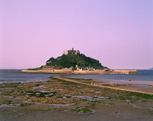 Prints of View of St Michaels Mount from the mainland, Cornwall. The Mount is united with nearby Marazion by a manmade causeway which can only be walked on at mid to low tide -- at high tide the sea covers it Mount Prints: View of St Michaels Mount, Cornwall Print - circa 1980s