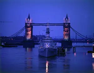 London Cityscape At Night Prints: View of Tower Bridge with a ship on the River Thames, London, by night. Date: circa 1960s