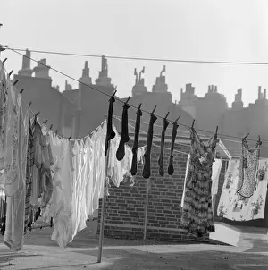 Prints of Lines of washing drying in the sun with the outlines of roofs and chimney pots behind, in an unidentified location in either Islington or Camden, in London Camden Prints: Lines of Washing Drying in the Sun Print