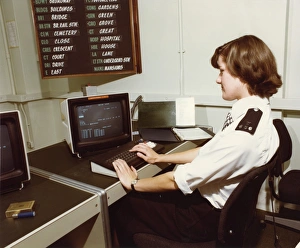 Woman police officer at work in communications room Woman police officer at work in communications room