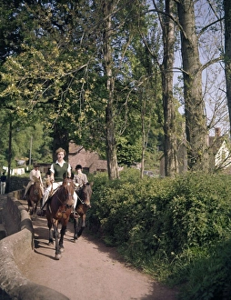Women and children riding horses along a country lane Women and children riding horses along a country lane