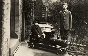 Railway Nostalgia Prints: Young boy in a model train with his elder brother