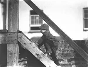 A young boy climbing wooden steps to the seafront, Print