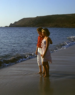 Young couple walking along a beach, West Country Young couple walking along a beach, West Country