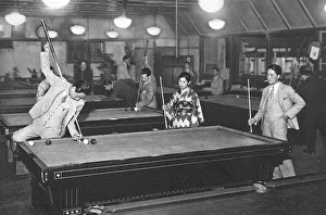 Three young Japanese people play billiards Three young Japanese people play billiards