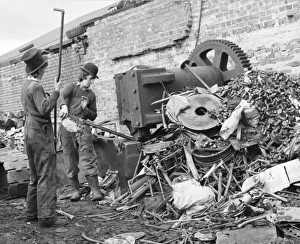 Two young men sorting through a pile of scrap metal Two young men sorting through a pile of scrap metal