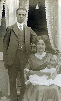 A young middle class couple pose for a photograph with their new little baby A young middle class couple pose for a photograph with their new little baby