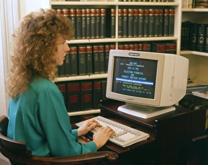 Young woman working at a computer in a solicitors office Young woman working at a computer in a solicitors office