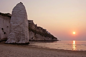 Beach of Vieste - with chalk cliffs and symbol Pizzomunno at sunrise Beach of Vieste - with chalk cliffs and symbol Pizzomunno at sunrise