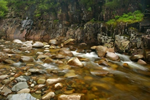 Etive river canyon - water flowing over red rocks in riverbed with steep canyon walls Etive river canyon - water flowing over red rocks in riverbed with steep canyon walls